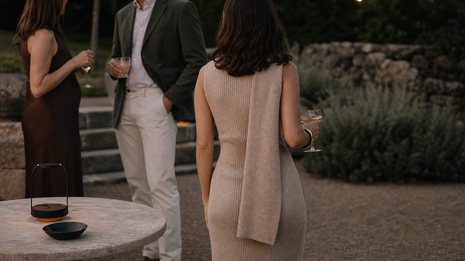 Guests at an outdoor evening event wearing polished but relaxed outfits.