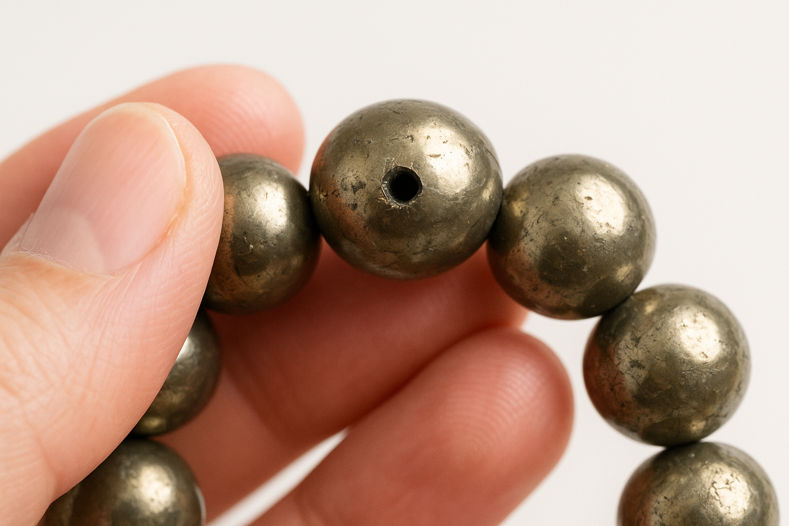 Check drill holes, bead symmetry, and surface chipping